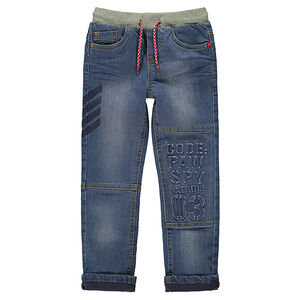 Jeans effet used doublé jersey élastiqué avec inscriptions en relief 