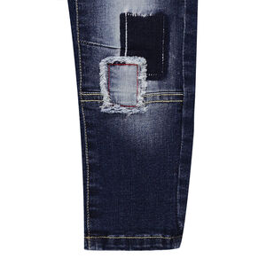 Jeans effet used fourche basse avec patchs et découpes 