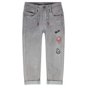 Jeans effet used avec taches printées et badges patchés 