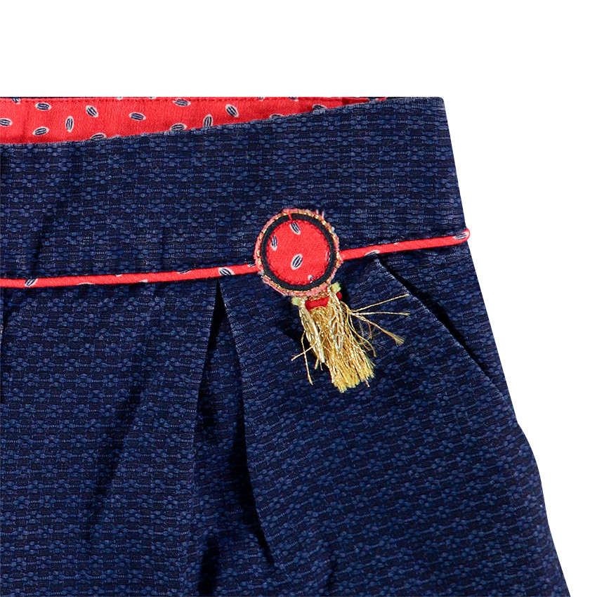 Short en faux-uni avec badge à franges et touches de rouge 