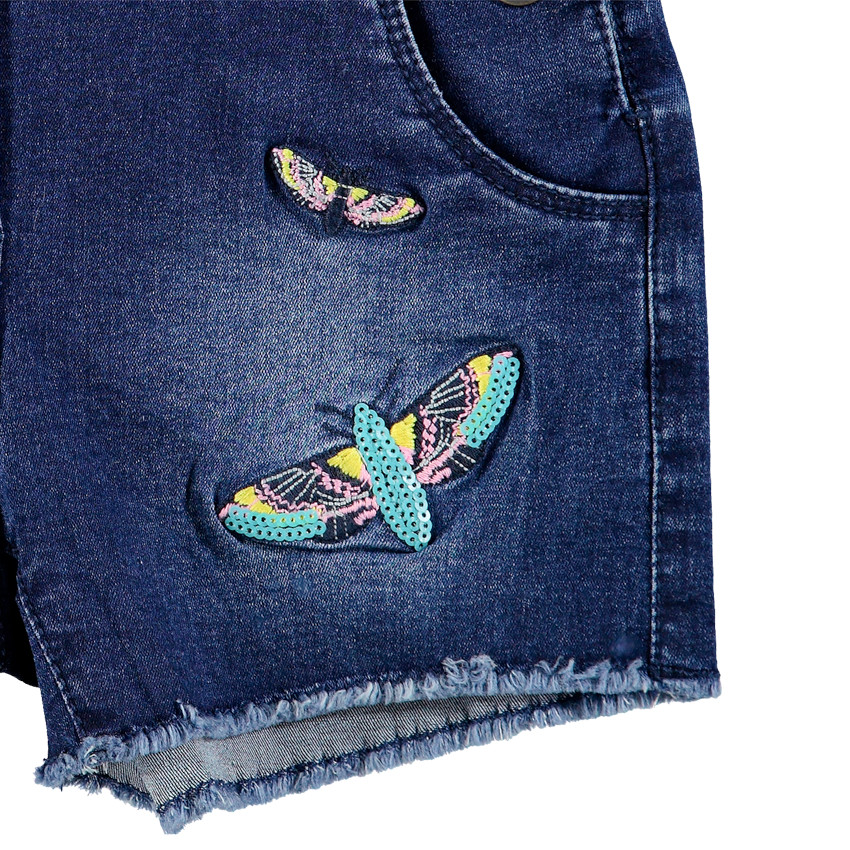 Salopette short en jeans effet used avec papillons brodés 