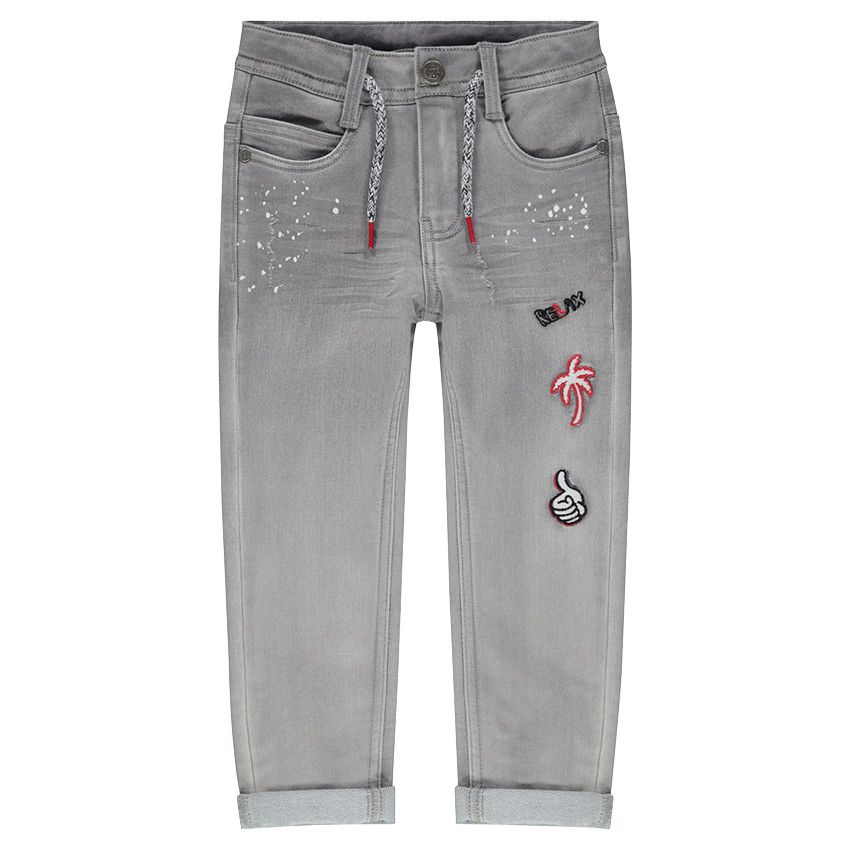 Jeans effet used avec taches printées et badges patchés 