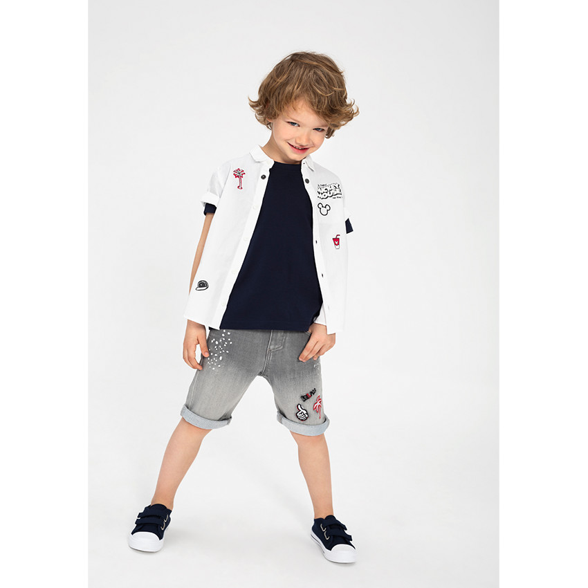 Bermuda en jeans effet used avec effet tacheté et badges fantaisie 