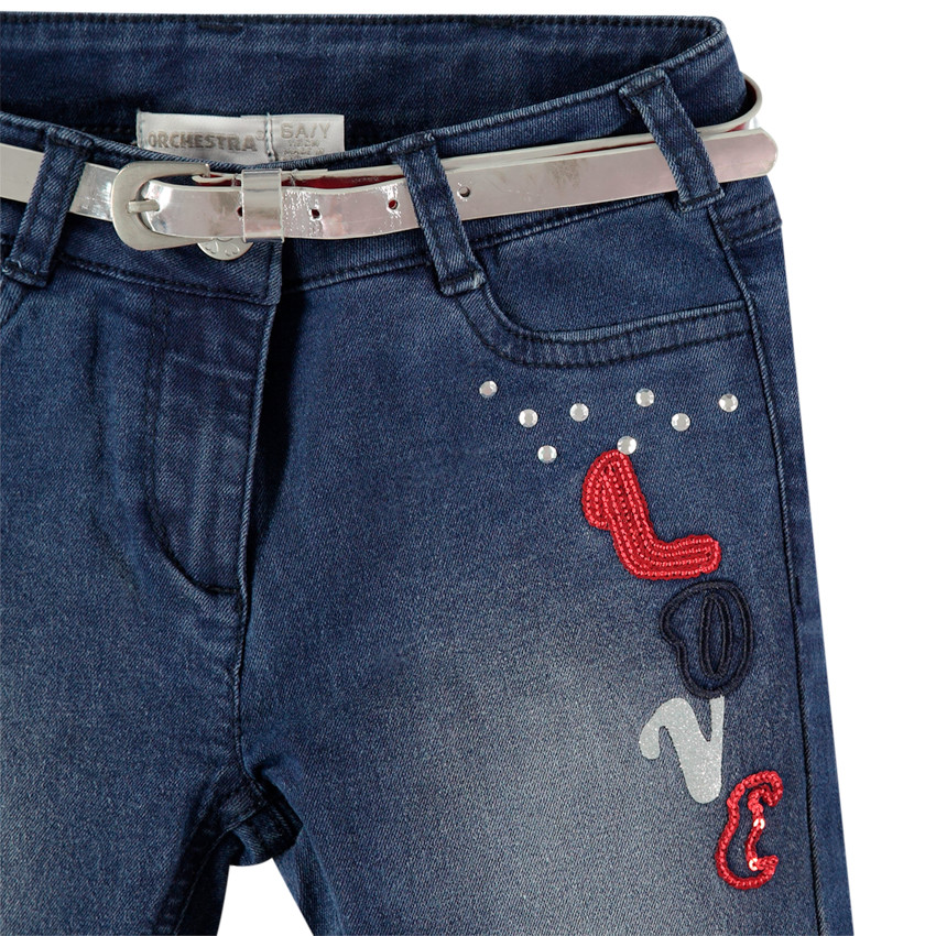 Jeans effet used à broderies contrastées et ceinture argentée 