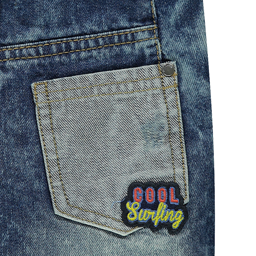 Bermuda en jeans effet used avec badges patchés et découpes 
